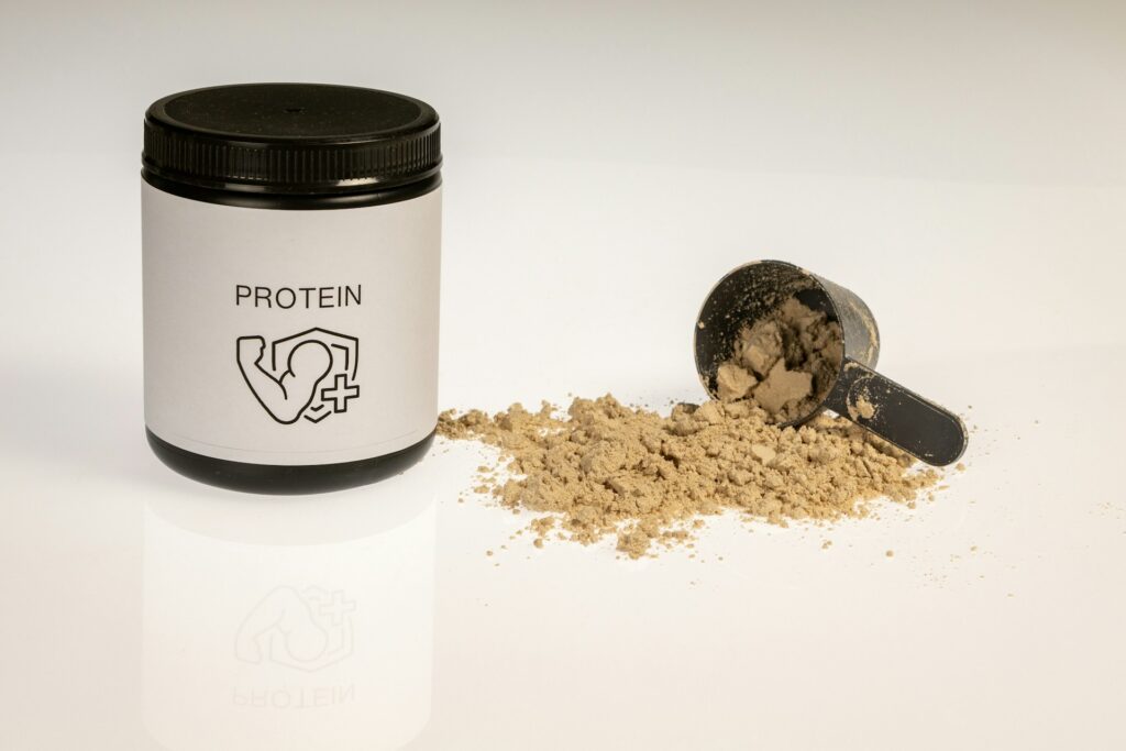 Photo by <a href="https://unsplash.com/@alexsaks?utm_source=unsplash&utm_medium=referral&utm_content=creditCopyText">Alex Saks</a> on <a href="https://unsplash.com/photos/a-jar-of-protein-powder-next-to-a-scoop-of-protein-powder-DvunqLOsKco?utm_source=unsplash&utm_medium=referral&utm_content=creditCopyText">Unsplash</a>
      
